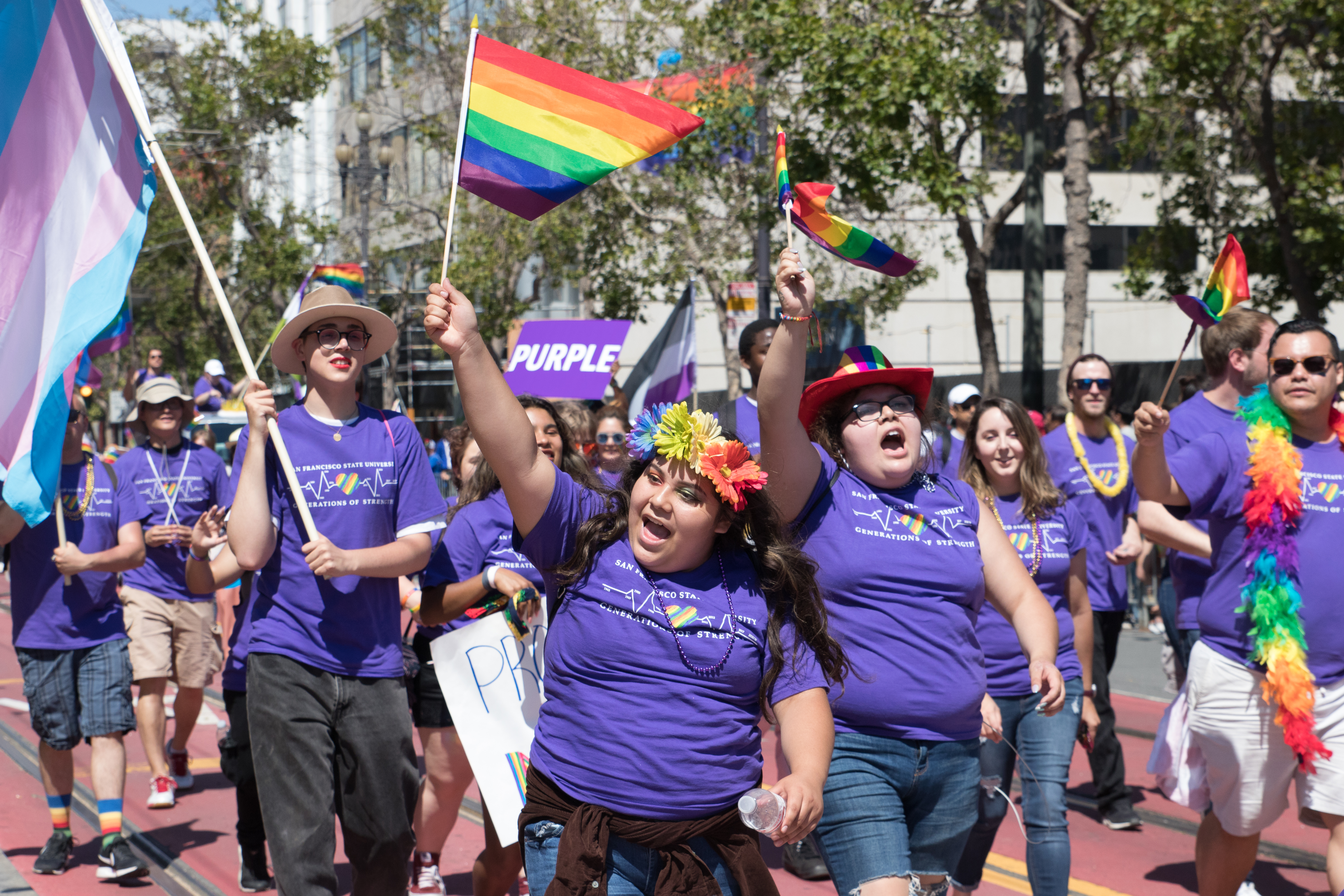 Students wave rainbow pride flags in a parade