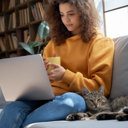 student reading their computer with a cat