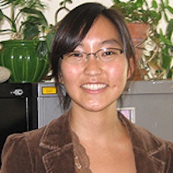 A picture of Julietta Hua with plants and filing cabinets in the background.