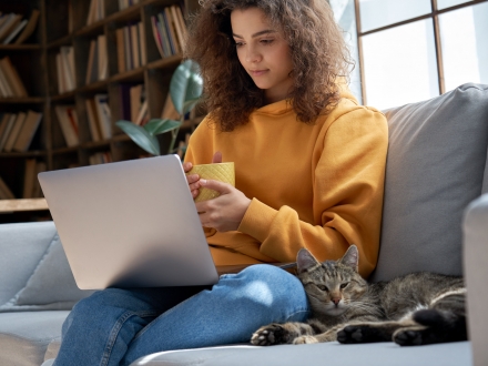 student reading their computer with a cat